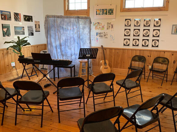 Black folding chairs set up around the performing area
